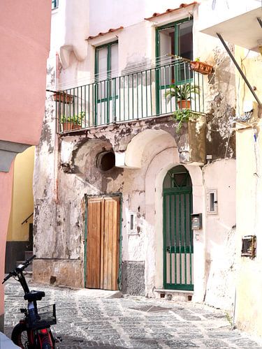 Rue ensoleillée de Procida avec une maison blanche et un vélo