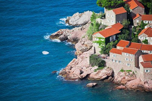 Mediterrane stad. kleine huizen met een pannendak en groene bomen aan de blauwe zee. geluk in ontspa