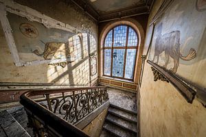 Treppenhaus mit Glasfenstern und Löwen