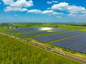 Trein van de Nederlandse Spoorwegen rijdt langs een veld met zonnepanelen van Sjoerd van der Wal Fotografie thumbnail