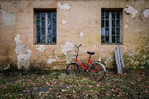 Rotes Fahrrad am verlassenen Haus