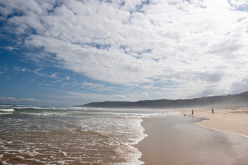Eindeloos Strand onder een Wolkenhemel