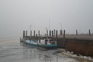 Boot im Eis eines Hafens in Friesland festgefroren