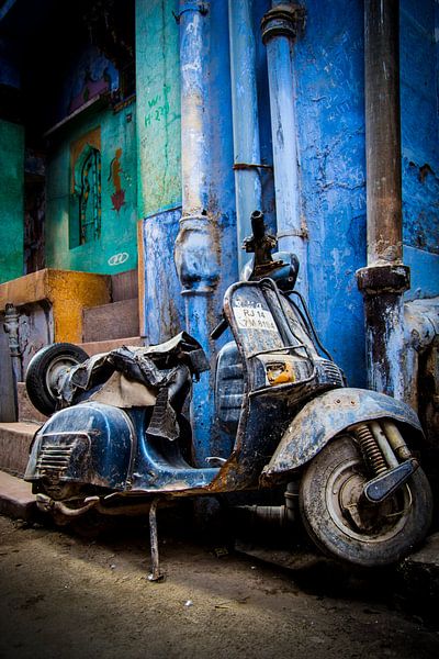 Blauwe verlaten scooter-brommer in de straten van India van Björn Jeurgens