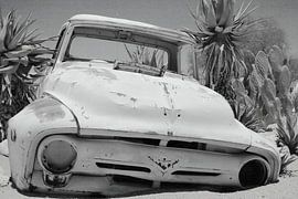 Altes verrostetes und verlassenes Oldtimer-Autowrack im Sand von Bobsphotography