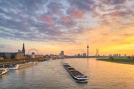 The Düsseldorf skyline with a ship on the Rhine at sunset by Michael Valjak