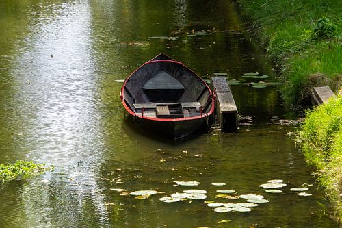 Stilleven met een roeiboot aan de steiger in de gracht in Edam.