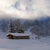 Berghut in de Sneeuw met openbrekende wolken van Guido Akster