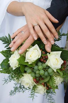 Hände eines Hochzeitspaares auf dem Brautstrauß von Jörg B. Schubert