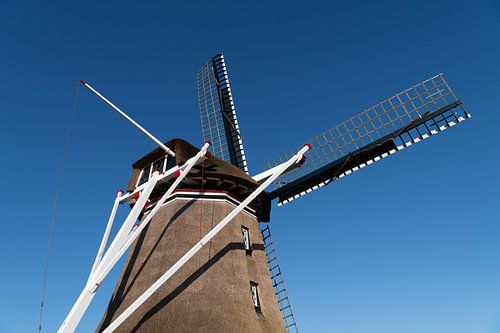 Top of a Dutch windmill against a clear blue sky