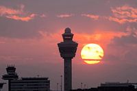 Ondergaande zon naast verkeerstoren Schiphol