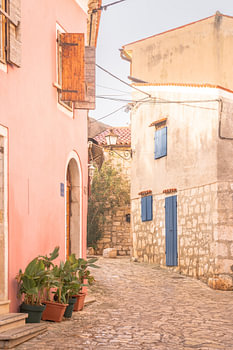 Colourful Mediterranean street with pink facade and blue shutters