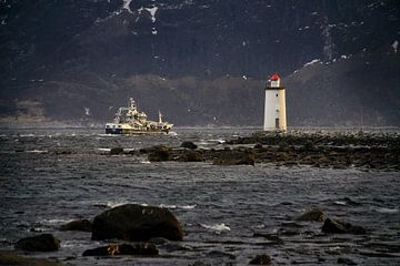 Een vissersboot vaart langs de vuurtoren van Høgstein op Godøy, Noorwegen van qtx