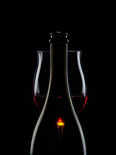 Een fles, een glas, rode wijn.