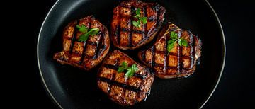 Grilled steaks on a black plate by Poster Art Shop