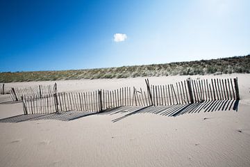 Houten hekwerk op het strand en één wolkje van Peter de Kievith Fotografie