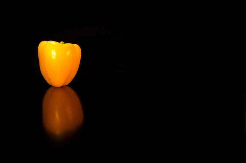 Pepper yellow reflection in black table by Marion Hesseling