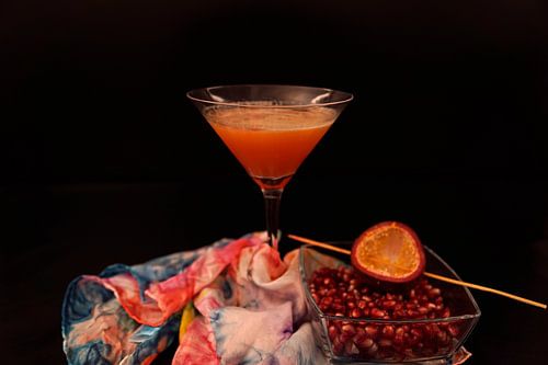 Cocktail met passievruchtensap, sinaasappellikeur, cranberrysap, wodka en verse passievrucht.