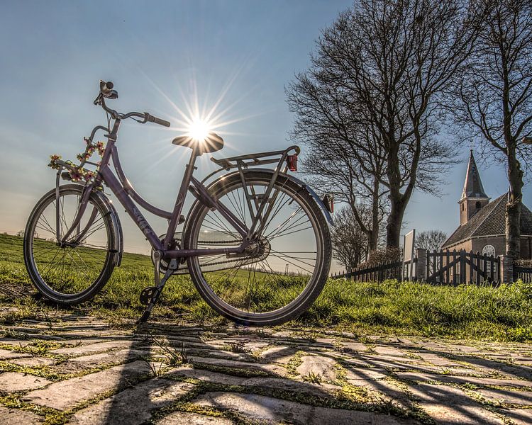 A ladies bike and the church of Haskerdijken in Friesland. by Harrie Muis