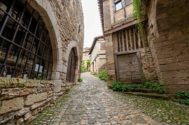 Mittelalterliche Kopfsteinpflasterstraße mit Steinbogen und alten Häusern in Frankreich von Fechita Florentina Catalina