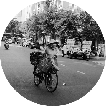 Vrouw met fiets loopt over straat in HCMC van Bart van Lier