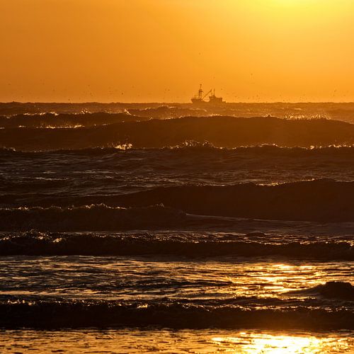 Netherlands, setting sun by fishing boat and wild sea