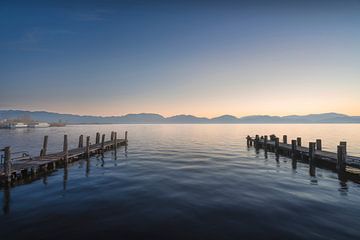Twee houten pieren bij zonsopgang in het Massaciuccoli meer van Stefano Orazzini