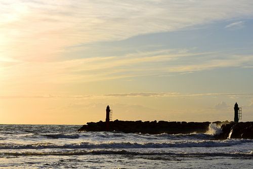 Zonsondergang bij de haveningang aan zee