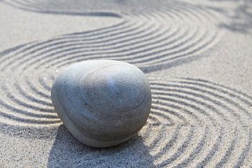 Stein auf Linien im Sand von Karina Baumgart