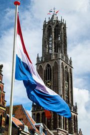 Nederlandse vlag wappert voor de Utrechtse Domtoren op Koningsdag. by Margreet van Beusichem