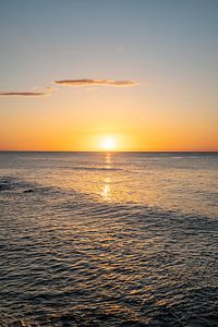 Sonnenaufgang am Strand an der Küste Sardiniens mit glitzerndem Meer