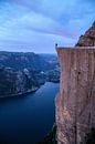 Man bij Preikestolen in Noorwegen - Blue Hour van Adalbert Dragon Dragon thumbnail