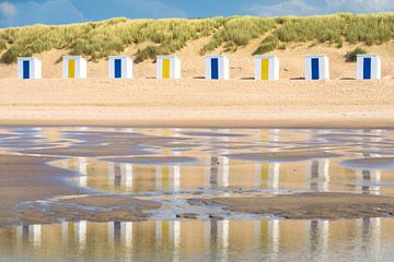 Strandhuisjes weerspiegeld in het water van de zee van Lisette Rijkers