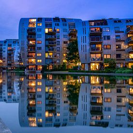 Appartementen weerspiegelen in het water. van Rene Siebring