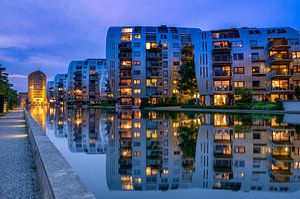 Appartementen weerspiegelen in het water. van Rene Siebring