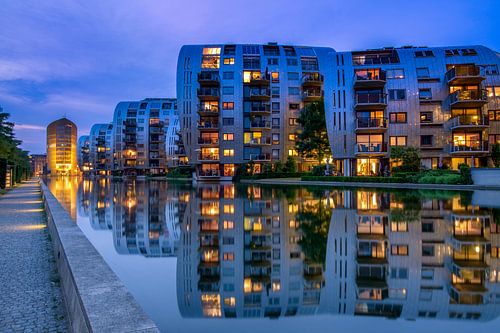 Apartments reflect in the water.