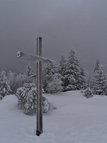 Frozen summit cross on the Schliffkopf in deep snow in winter