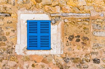 Oude mediterrane blauwe vensterluiken en stenen muur achtergrond met kopieerruimte van Alex Winter