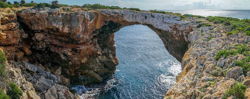 Zicht op een stenen boog in Mallorca met de zee en de lucht op de achtergrond van Hans-Heinrich Runge