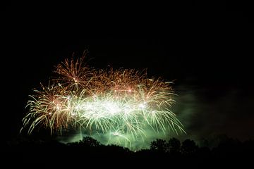 Giant green and orange fireworks explosions at big celebration by adventure-photos