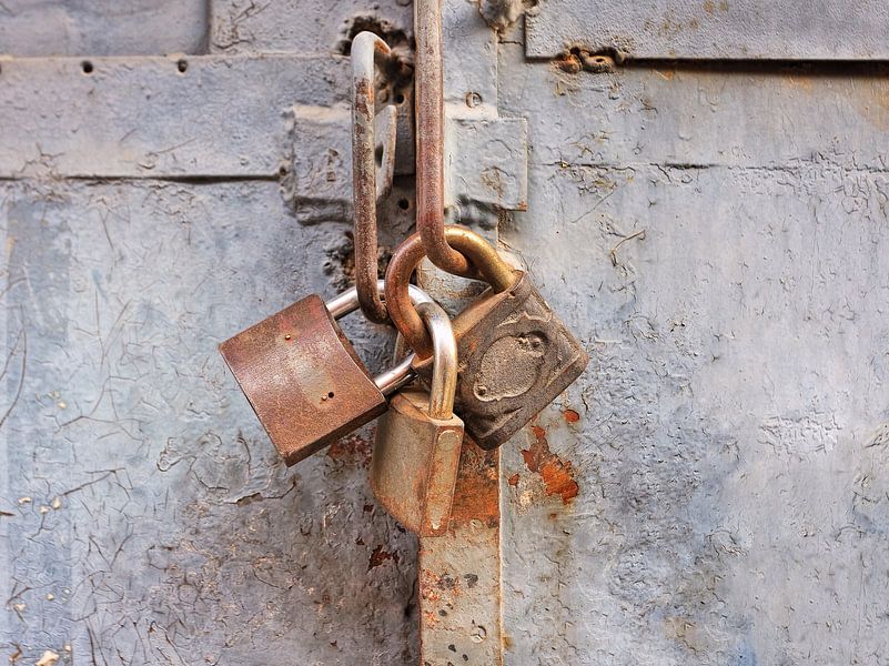 Rusty Vorhängeschloss auf einem alten grau lackierten Metall-Gate von Tony Vingerhoets