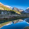 Grundsee met weerspiegeling van de bergen in het Lötschental. van Ad Van Koppen