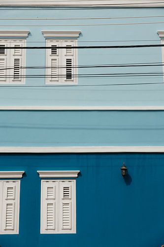 Prachtige blauwe gevels met shutters en stroomkabels in Willemstad op Curaçao