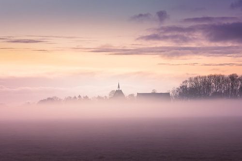 Het kerkje van Garmerwolde (Groningen) in de mist bij ochtendgloren