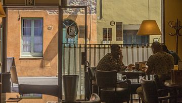 Mannen aan tafel in koel  in klein cafeïne  spaans plaatsje Palafrugell, Costa Brava van george vogelaar
