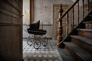 Oude kinderwagen in een huis