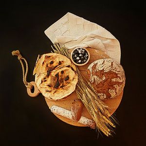 Stilleben mit Brotmik, Fladenbrot, Salami, Weizen und Heidelbeeren.