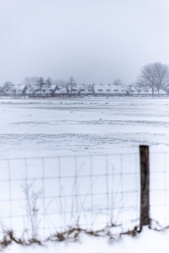 A Dutch village in the snow behind a fence
