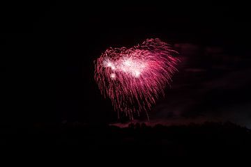 Prachtige roze vuurwerkexplosie die de nachtelijke hemel verlicht van adventure-photos