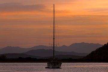 Sailing boat with Kefalonia's mountains in the background contrasting against the beautiful morning light. by Stef Heijenk